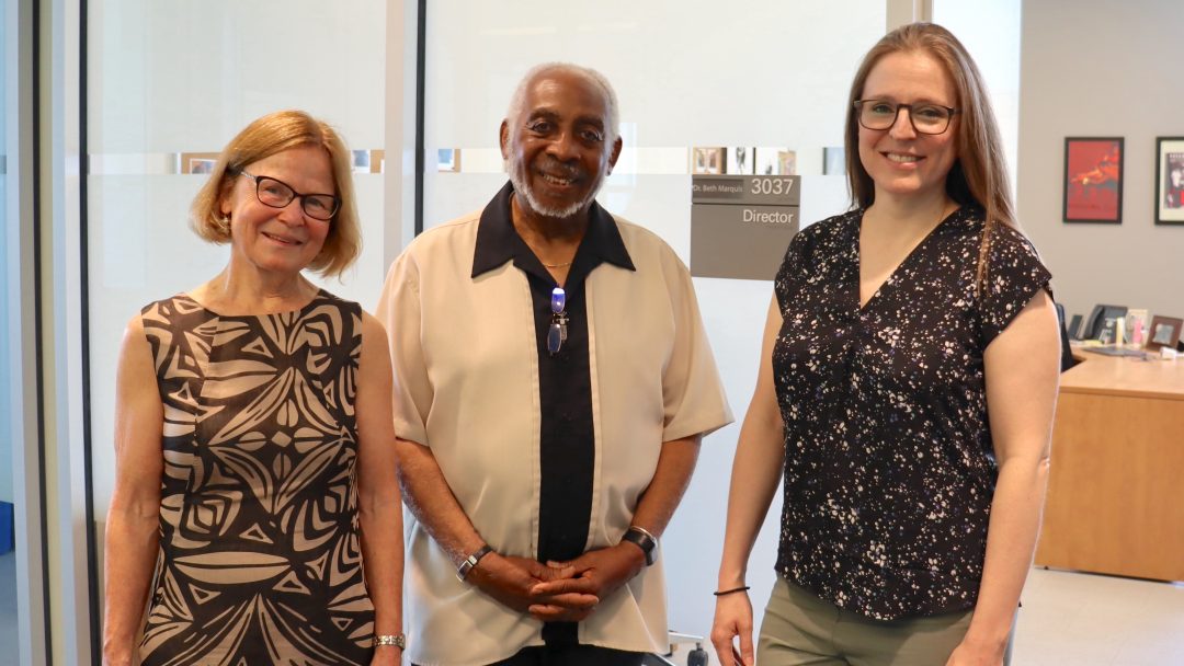 Three people standing together in front of the Program Director's Office