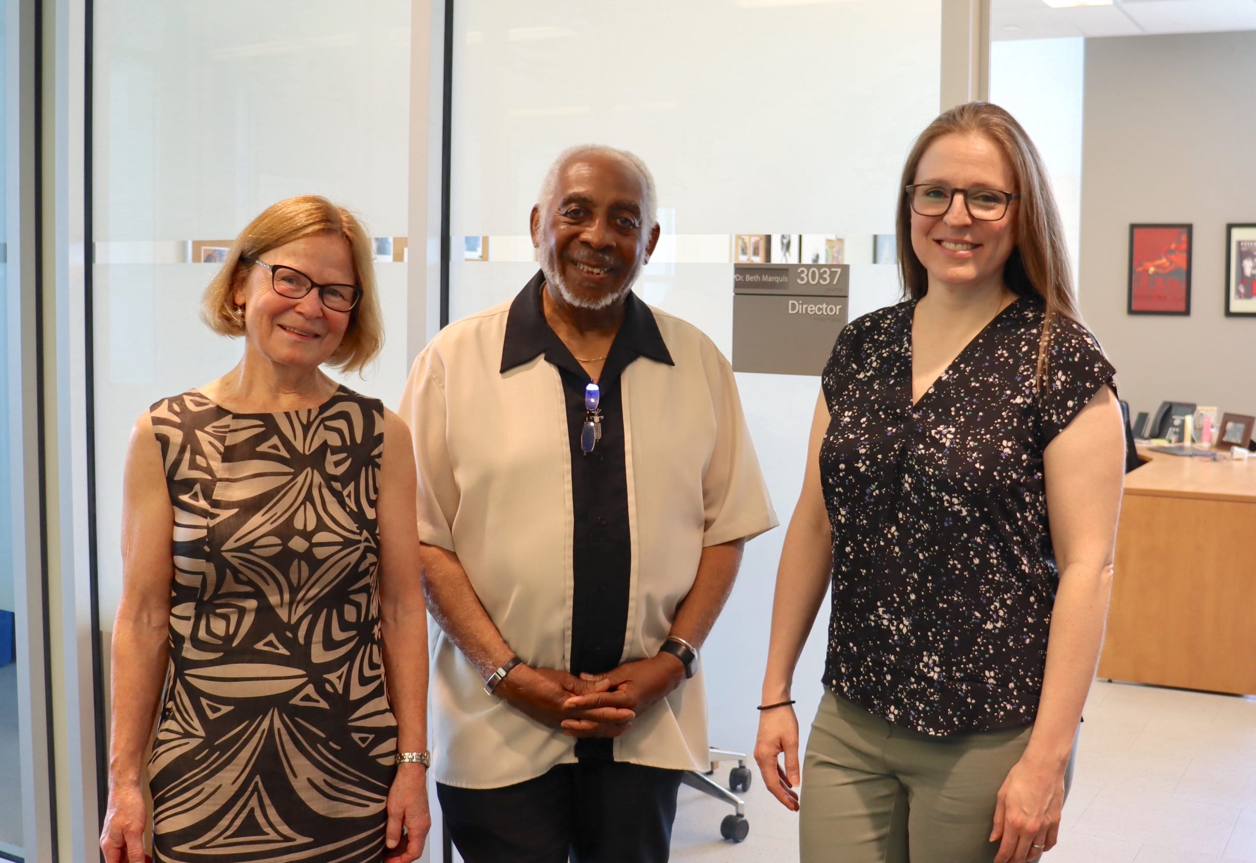 Three people standing together in front of the Program Director's Office