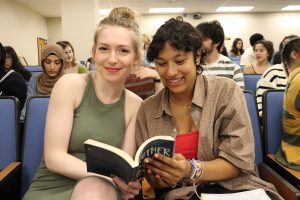 Two students sitting together looking at the book, "Brother"